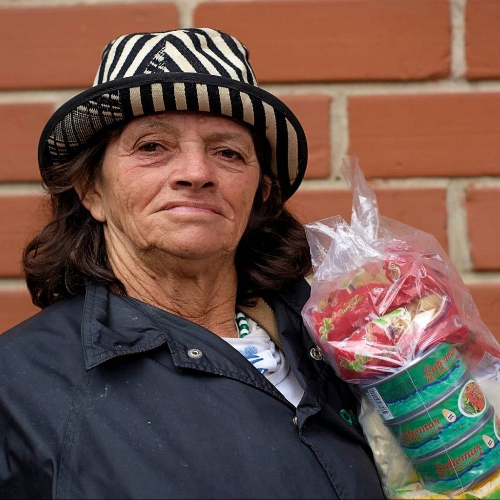 woman with hat happy with food bag