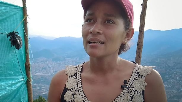 Women talking to the camera with view over Medellin in the background